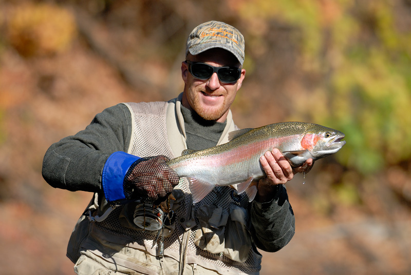 A friend with a beaming smile holding a hot steelhead